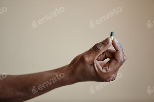 Preview: Male hand holding single capsule pill