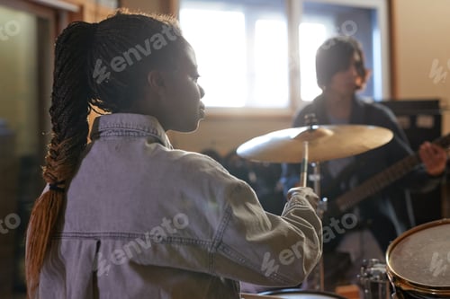 Preview: Black Young Woman Playing Drums in Rock Band