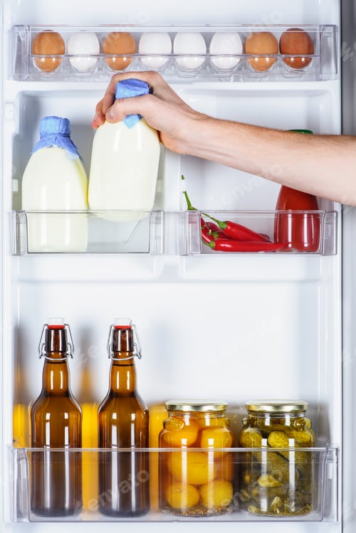 Preview: cropped image of man taking bottle of milk from fridge