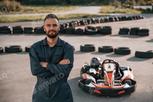 Preview: Man in Racing Suit Standing Near Go-Kart