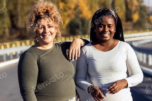 Preview: Portrait of two young plus size women preparing for jogging together.