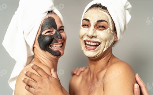 Preview: Happy women with facial mask having skin care spa day - People selfcare lifestyle concept