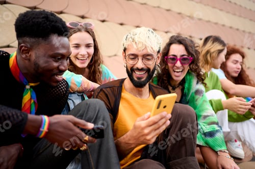 Preview: Group diverse people enjoying day together outdoors with mobiles in hand. Young multiracial friends.