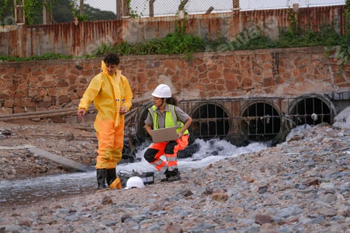Preview: Environmental field team in protective gear analyzes water samples on a polluted beach.