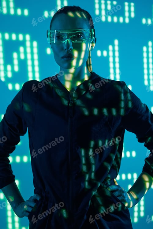 Preview: Beautiful young woman in futuristic glasses standing against colorful background