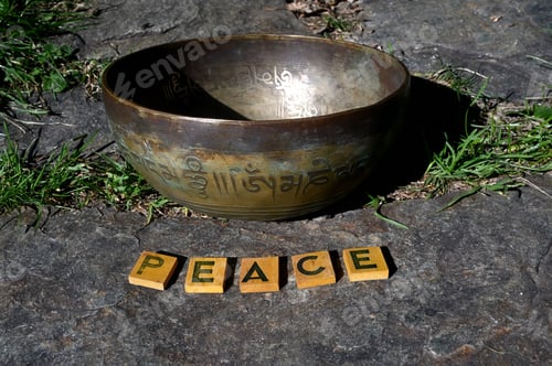 Preview: Singing bowl outdoor and wooden letters forming the word PEACE.
