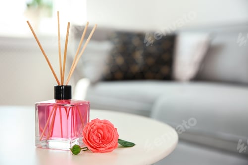 Preview: Aromatic reed air freshener and rose on table indoors