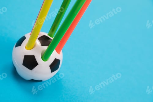 Preview: A round soccer ball shape pencil cup with five colorful pencils in it on azure surface isolated