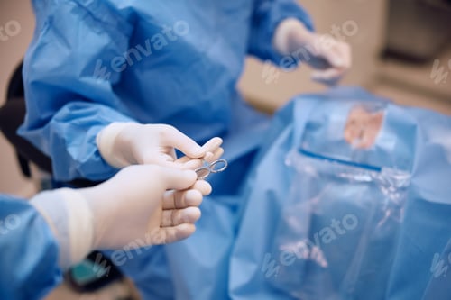 Preview: Close up of nurse assisting eye surgeon in operating room at the clinic.