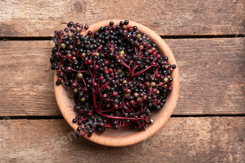 Preview: Bowl with tasty elderberries (Sambucus) on wooden table, top view