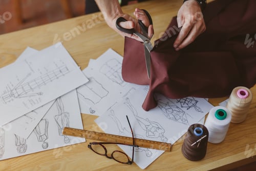 Preview: Man cutting fabric with scissors on table