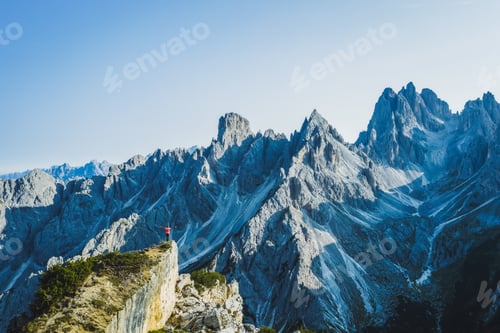 Preview: Aerial view of a man with raised hands enjoying Cadini di Misurina mountain peaks, Italian Alps