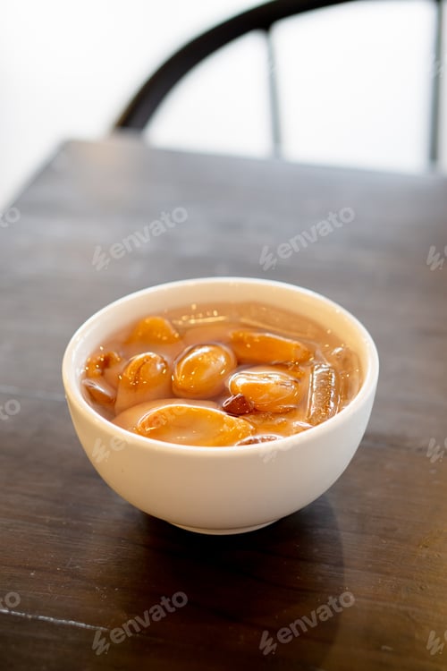 Preview: Bowl of sweet longan dessert on wood surface