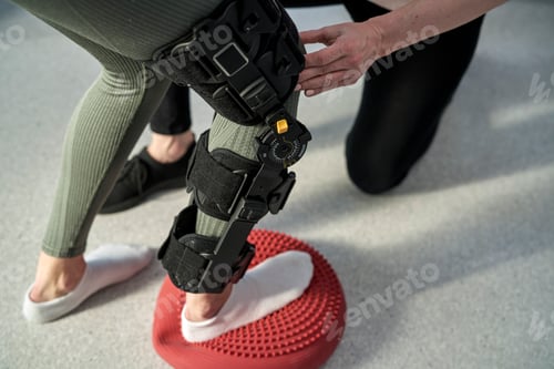 Preview: Young woman with orthosis working with physical therapist