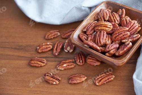 Preview: pecan nuts in wood bowl on old brown table, selective focus. top view. Healthy food and snack.