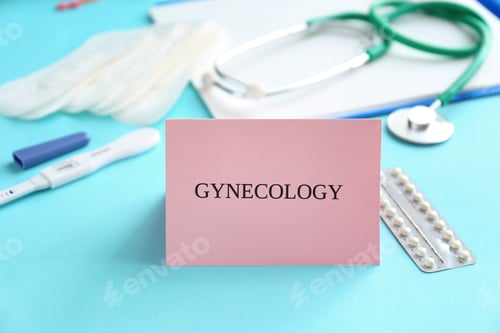 Preview: Card with word GYNECOLOGY and birth control pills on table