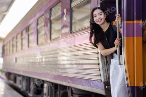 Preview: Young asian woman smiling, traveling by train through station