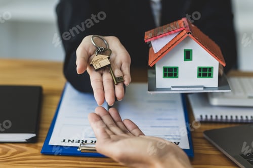 Preview: Real estate agent holding keys and model house showing to client, rental house concept.