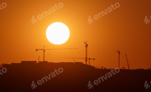 Preview: Sunset silhouette of construction site with cranes