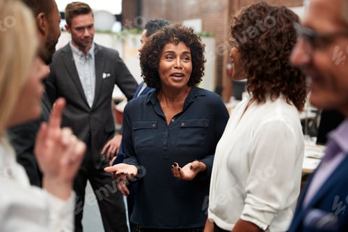 Preview: Business Team Standing Having Informal Meeting In Modern Office