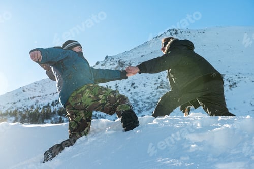 Preview: Climber assists another climber on the slope of snowy mountains