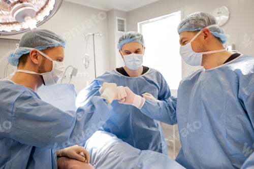 Preview: Dedicated Medical Team Fist Bump in Operating Room