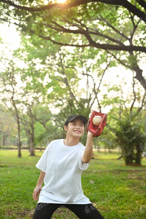 Preview: Shot of teenage Asian girl wearing leather glove playing baseball at public park