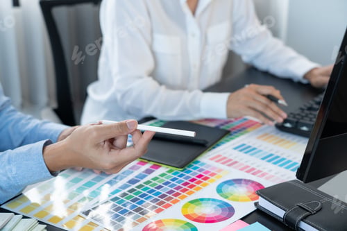 Preview: graphic designer team working on web design using color swatches editing artwork using tablet and a
