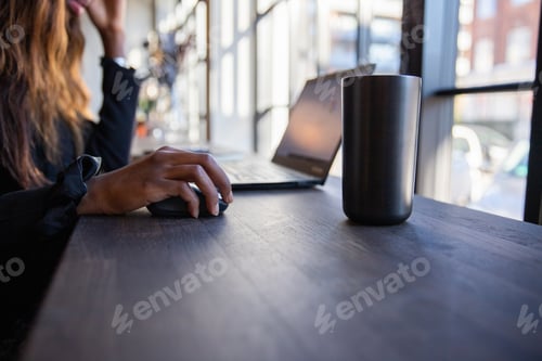 Preview: Close-up of the hand of a black business woman using her computer mouse in the office.