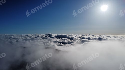 Preview: Stunning view of the clouds over the mountains covered in dense trees at sunlight