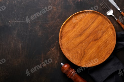 Preview: Vintage silverware. Rustic vintage set of wooden spoon and fork on wooden platter on black wooden ba