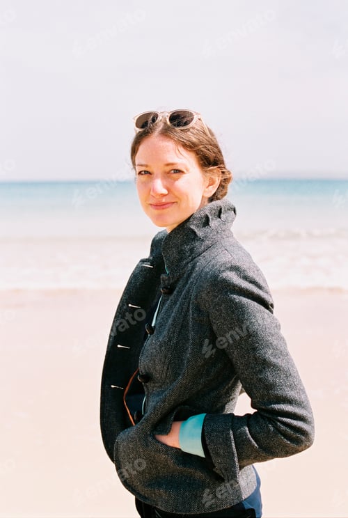 Preview: A woman in a grey coat on the beach.