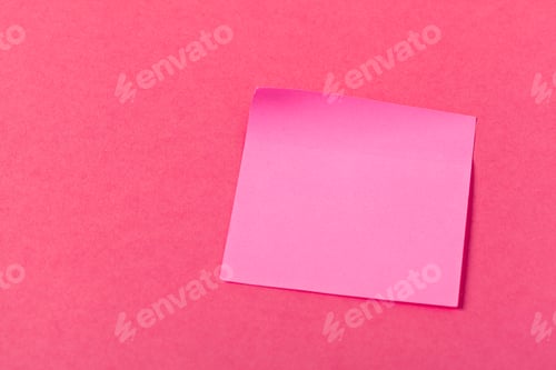 Preview: Bright pink sticky note on vibrant pink background in simple office setting