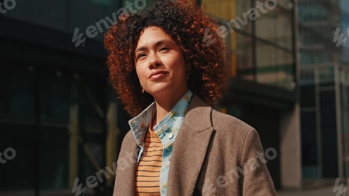 Preview: Curly-Haired Woman In Brown Jacket In The City