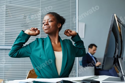 Preview: Woman stretching at her workplace resting after work