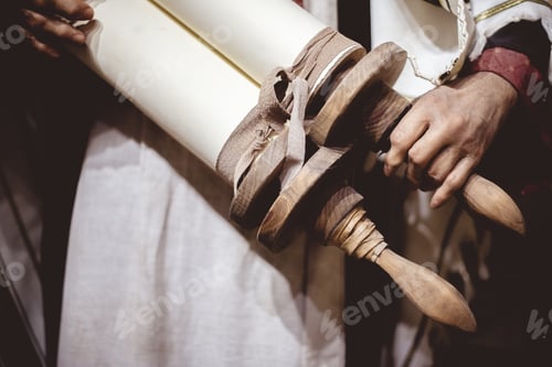 Preview: Closeup shot of a person holding a vintage rolled list of a papers