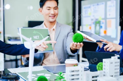 Preview: Trio of businesspeople, including a middle-aged Asian man and woman, strategize at their desk