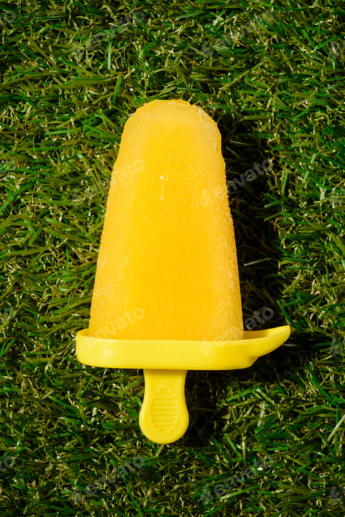 Preview: Yellow ice pop on green grass background