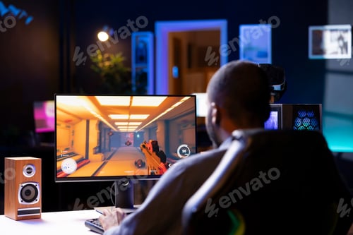 Preview: Man in living room playing video games on gaming PC at computer desk