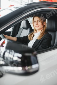 Preview: young beautiful business woman sitting in her car.
