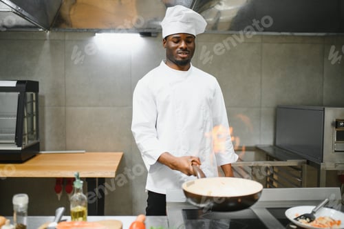 Preview: African American male chef frying vegetables in restaurant kitchen