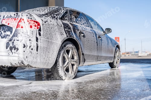Preview: Foamy car at car wash, with tire, wheel, and hood covered in suds