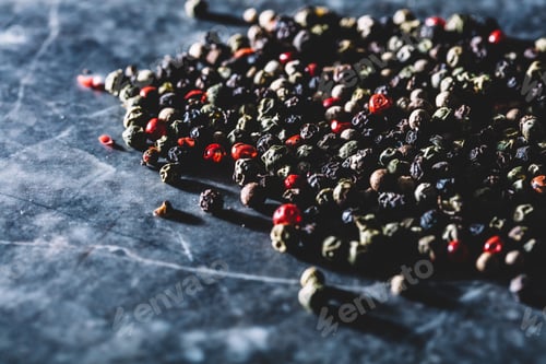 Preview: Grains of mixed pepper spilled on counter