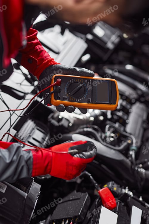 Preview: Mechanic checking battery of car in workshop