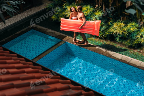 Preview: Couple having fun at the swimming pool. The couple is relaxing by the pool on site