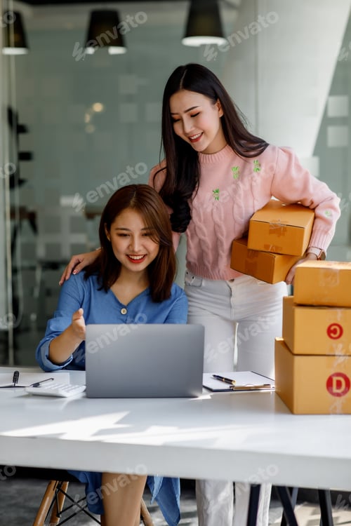 Preview: Two Young Asian women are happy and excited after a new order from SME customer, commercial checking