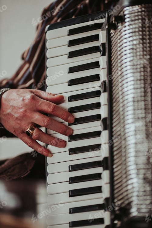 Preview: Vertical shot of a male's hand on top of an Organ keyboard