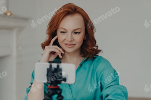 Preview: Photo of positive redhead woman blogger influencer shoots video for personal blog