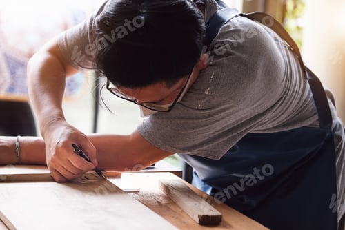 Preview: A carpenter measures the planks to assemble the parts, and build a wooden table for the customer