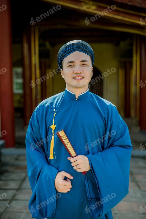 Preview: Smiling Asian man in blue traditional clothes with cap